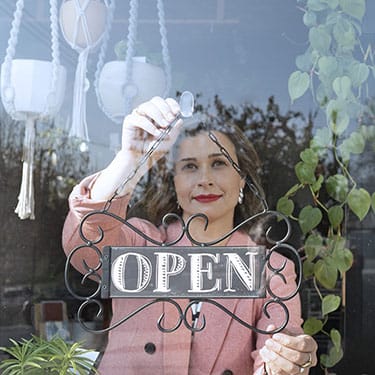 Vyvanse® patient flipping an open for business sign.